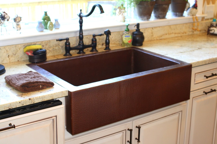 a kitchen sink sitting under a window next to a faucet and counter top