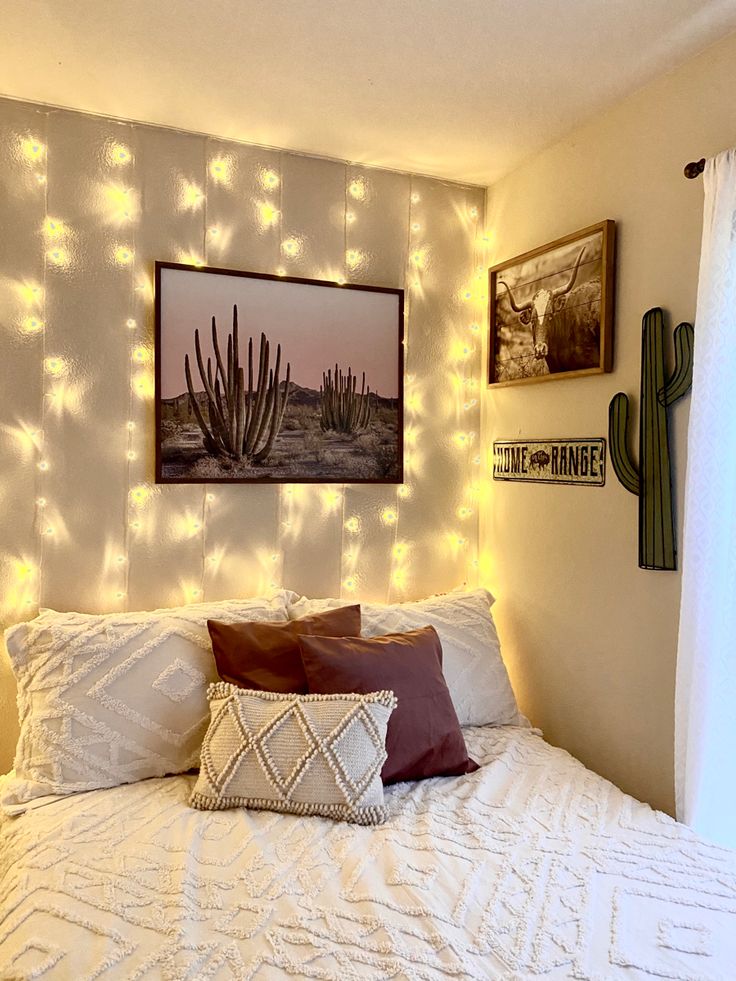 a white bed topped with lots of pillows next to a painting on the wall above it