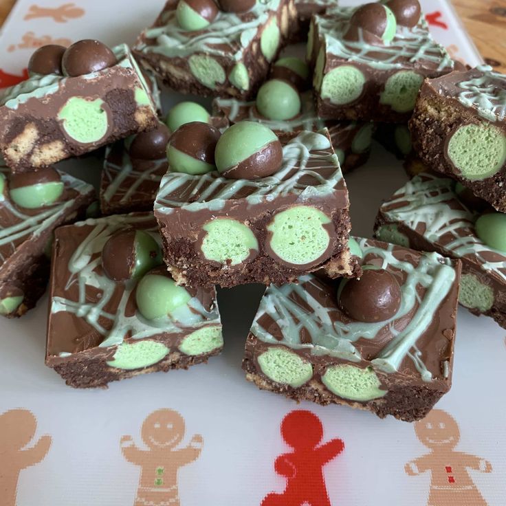 there are many brownies with green and white decorations on the table next to each other