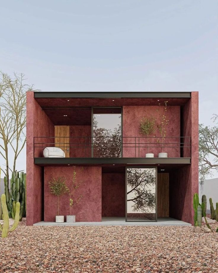 a pink house with cactus trees in the back ground and two windows on each side