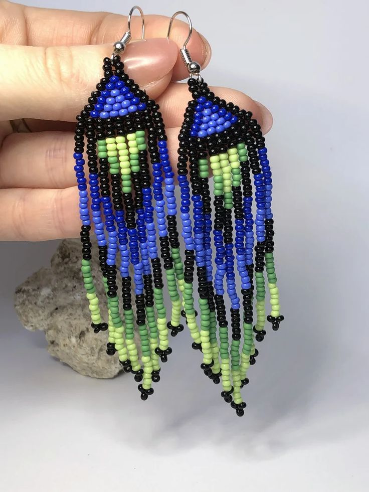 a pair of handmade beaded earrings in blue, green and black with beads