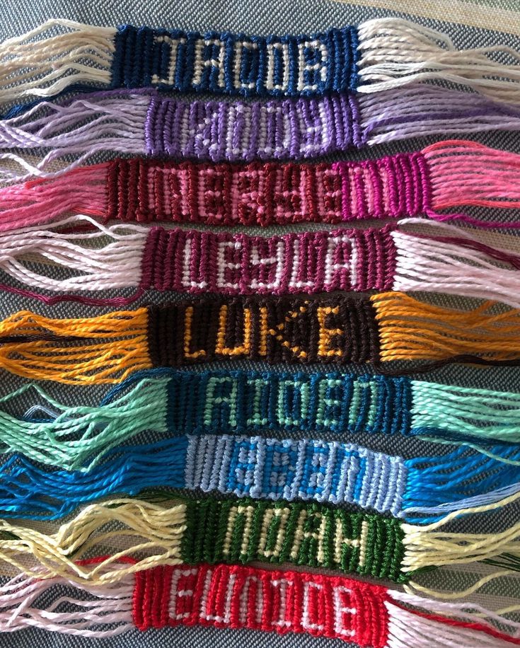 many different colored threads are stacked together on a tablecloth with words written in the middle