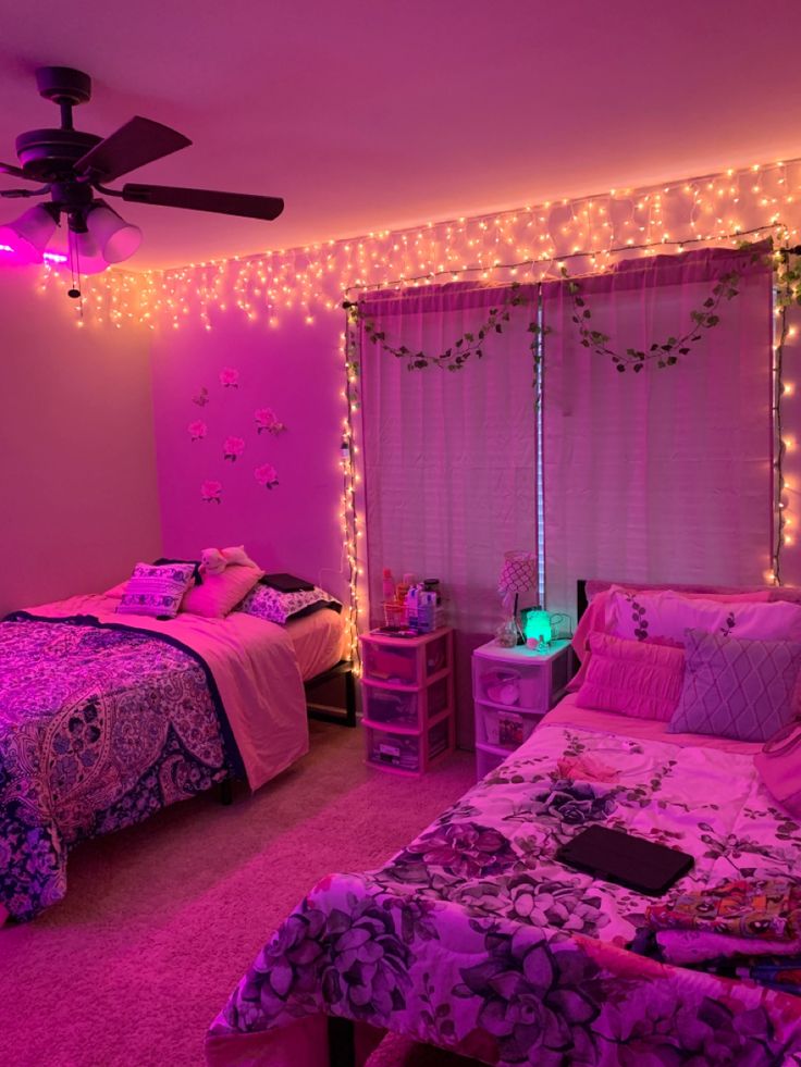 a bedroom decorated in pink and purple with fairy lights