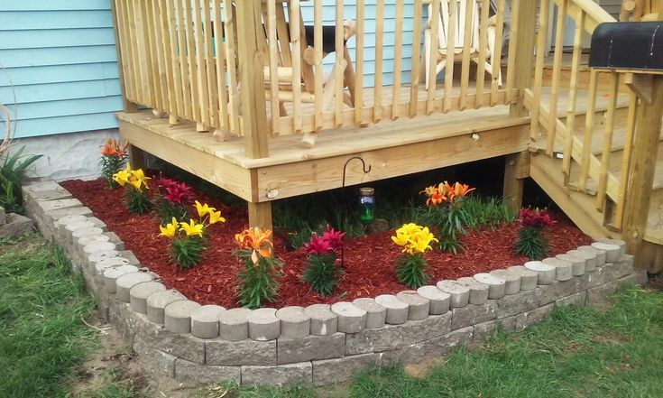 a wooden deck with flowers in the flower bed