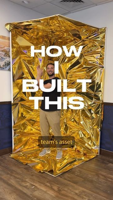 a man standing in front of a gold foiled backdrop with the words how i built this