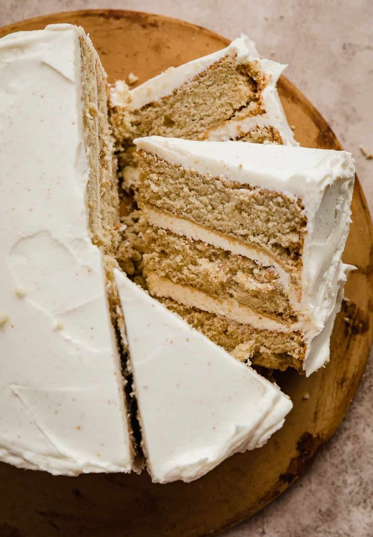 a cake with white frosting is cut into slices