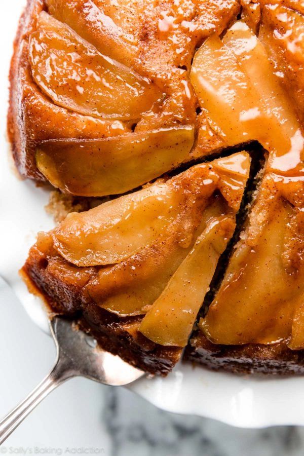 a piece of apple upside down cake on a white plate with a fork in it