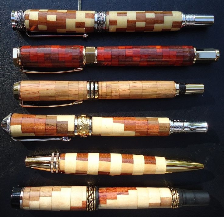 four different types of fountain pens lined up on top of each other, all in wood and metal