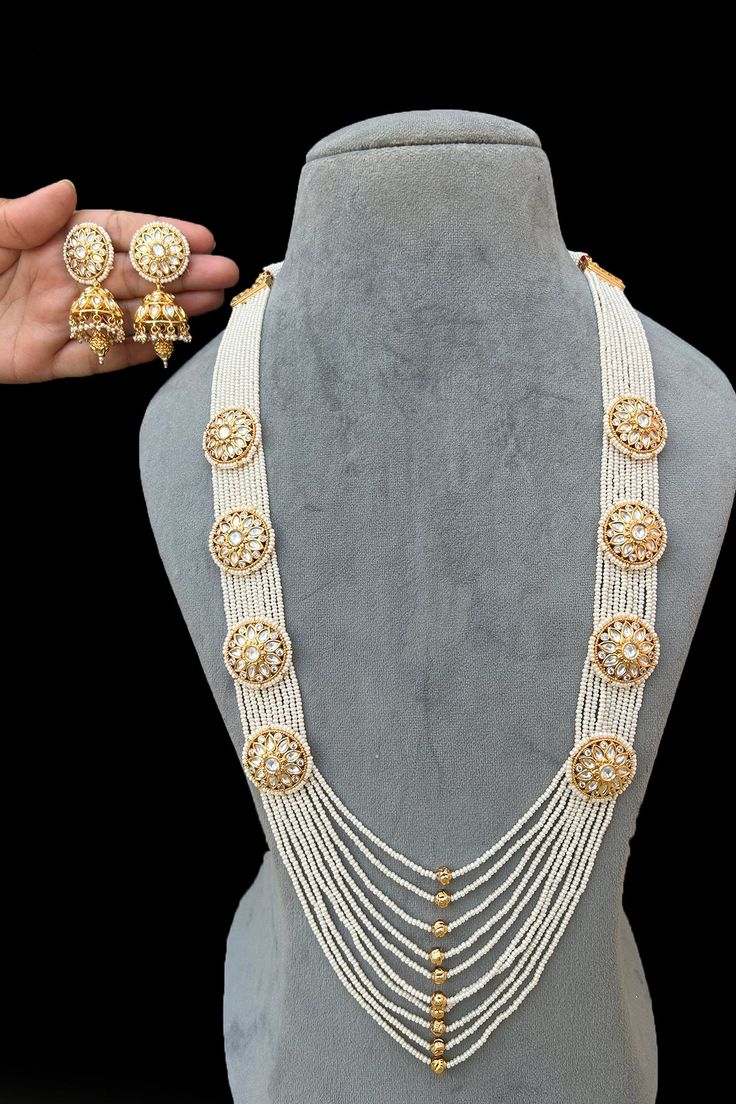 About : Exotic and snag-free beaded necklace set with earrings. This is a stylish set with Kundan Red, White & Golden Beads. This set will work well with traditional, formal, and western formals Details : Eye-catching and unique jewelry that will set you apart. Gift this piece to a loved one, and see their face light up with joy. Best for gifting or for personal use, wear it to any occasion and become the spotlight. Elegant Jewelry With Gold Beads For Diwali, Elegant Gold Beaded Jewelry For Diwali, Traditional White Jewelry With Gold Beads, Bollywood Style Necklace With Hand Set Round Beads, Traditional Pearl Beaded Necklace With Gold Beads, Traditional Pearl Bridal Necklace With Round Beads, Festive Temple Jewelry Pearl Beaded Necklaces, White Beaded Jewelry Sets For Festivals, Traditional Pearl Beaded Bridal Necklace