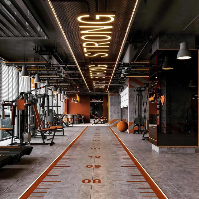 an indoor gym with rows of machines and exercise mats on the floor, along with neon lights