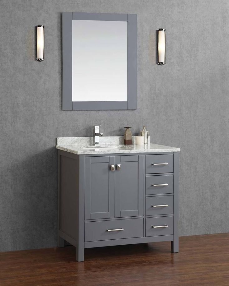 a bathroom vanity with a mirror above it and lights on the wall next to it