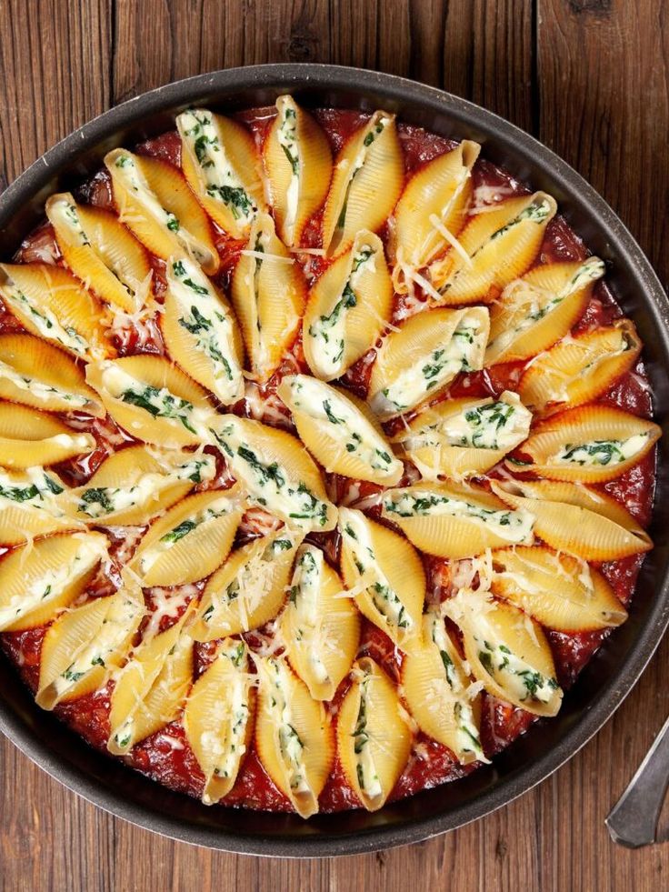 a pan filled with pasta and sauce on top of a wooden table