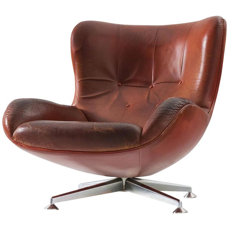 a brown leather chair with chrome legs and footrests on an isolated white background