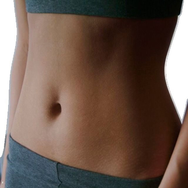 a close up of a woman's stomach with no shirt on and her hand in her pocket