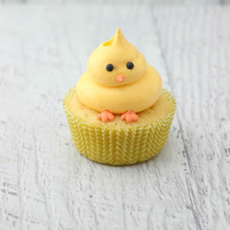 a yellow cupcake sitting on top of a white table