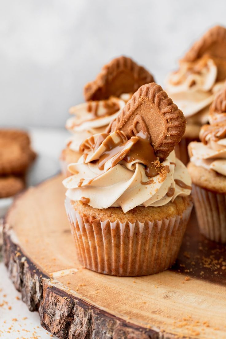 cupcakes with frosting and cookies on a wooden board