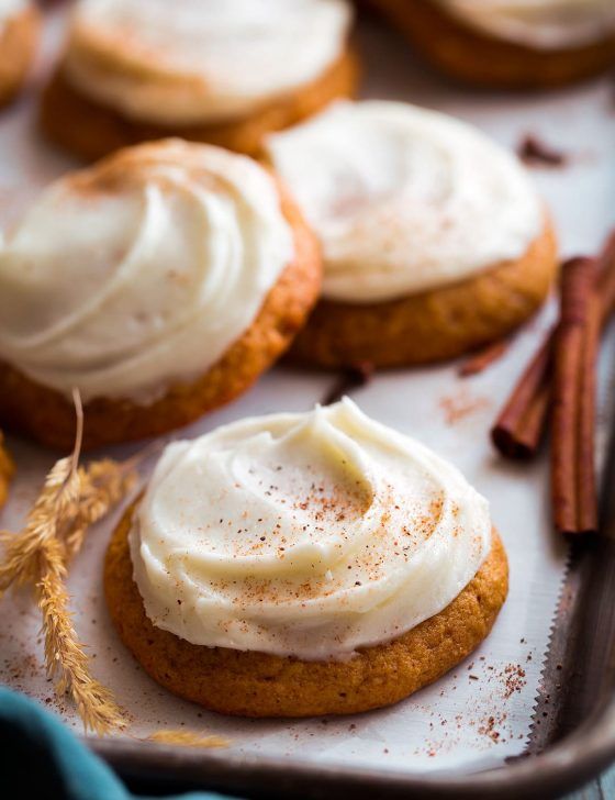 cookies with icing and cinnamon sticks on a baking sheet, ready to be eaten