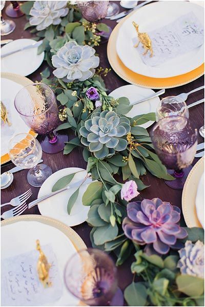 the table is set with flowers and plates