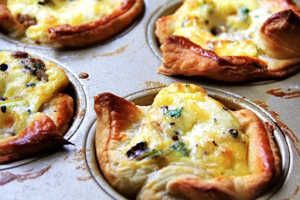 four mini quiche pies sitting in a muffin tin