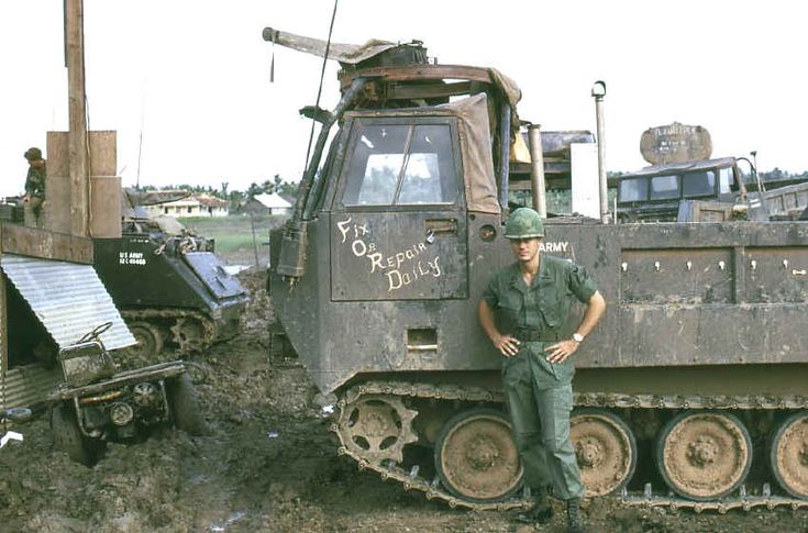 a man standing in front of an old bulldozer