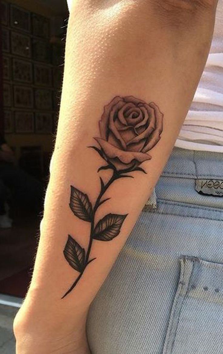 a woman's arm with a rose tattoo on it