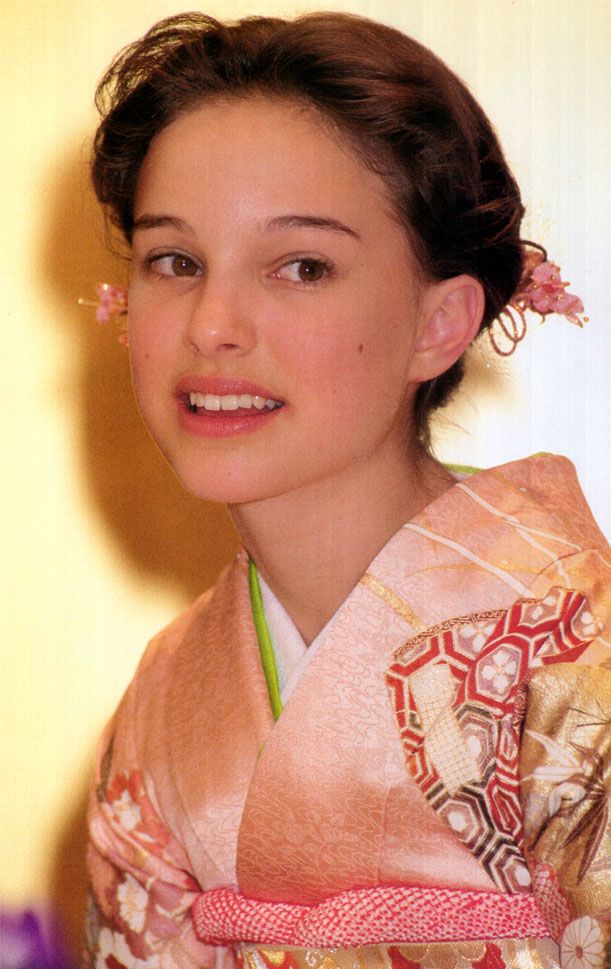 a woman in a kimono is smiling for the camera