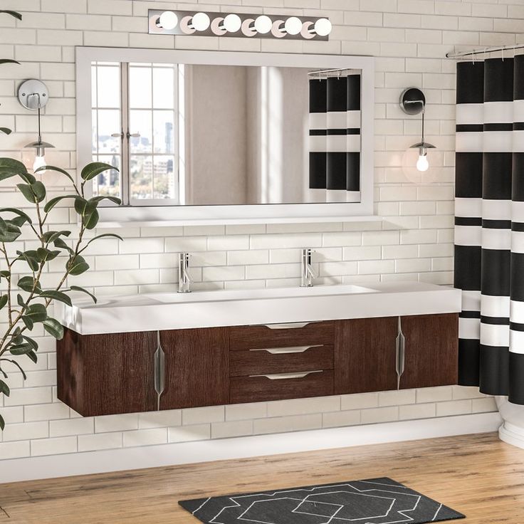 a bathroom with black and white striped shower curtain, wooden sink vanity and large mirror