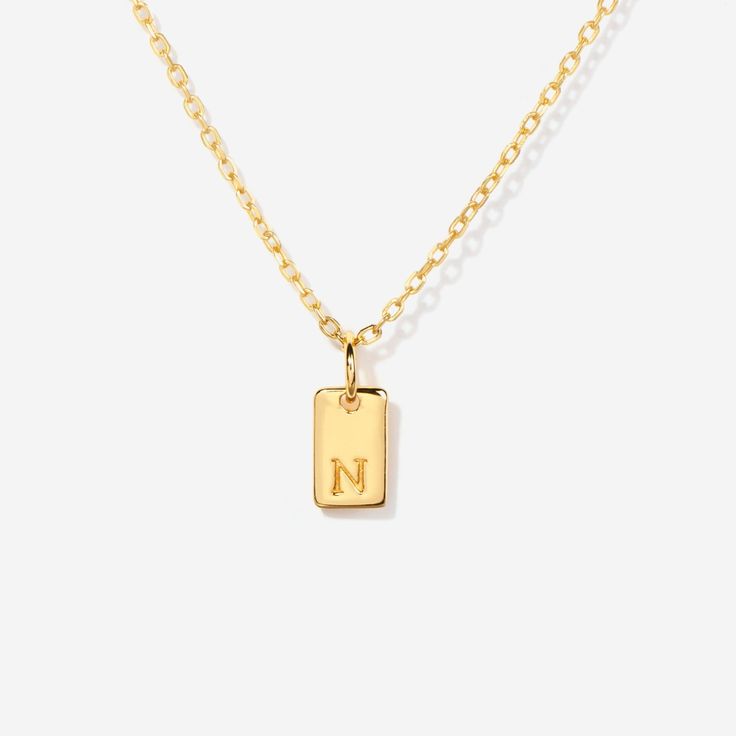 Embrace timeless elegance with this chic initial tag charm, a versatile piece designed to add a personal touch to any ensemble. Featuring a sleek, rectangular silhouette with a subtly embossed initial, this charm crafted from lustrous material is perfect for personalizing your favorite chain, bracelet, or accessory. Ideal for layering or as a standalone statement, this charm is a stylish way to keep a special initial close to your heart. Charm size: 10 mm x 5 mm Made of 14K gold over sterling si Elegant Personalized Dog Tag Charm Necklaces, Elegant Personalized Dog Tag Charm Necklace, Classic Gold Rectangular Charm Necklace, Elegant Personalized Charm Necklace With Rectangular Pendant, Elegant Charm Necklace With Rectangular Pendant, Elegant Rectangular Pendant Charm Necklaces, Modern Personalized Rectangular Jewelry, Classic Rectangular Jewelry For Personalized Gifts, Elegant Yellow Gold Rectangular Initial Necklace