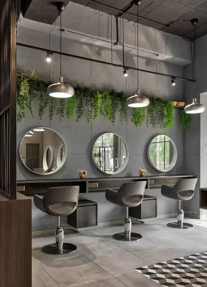 a salon with mirrors and stools, plants on the wall