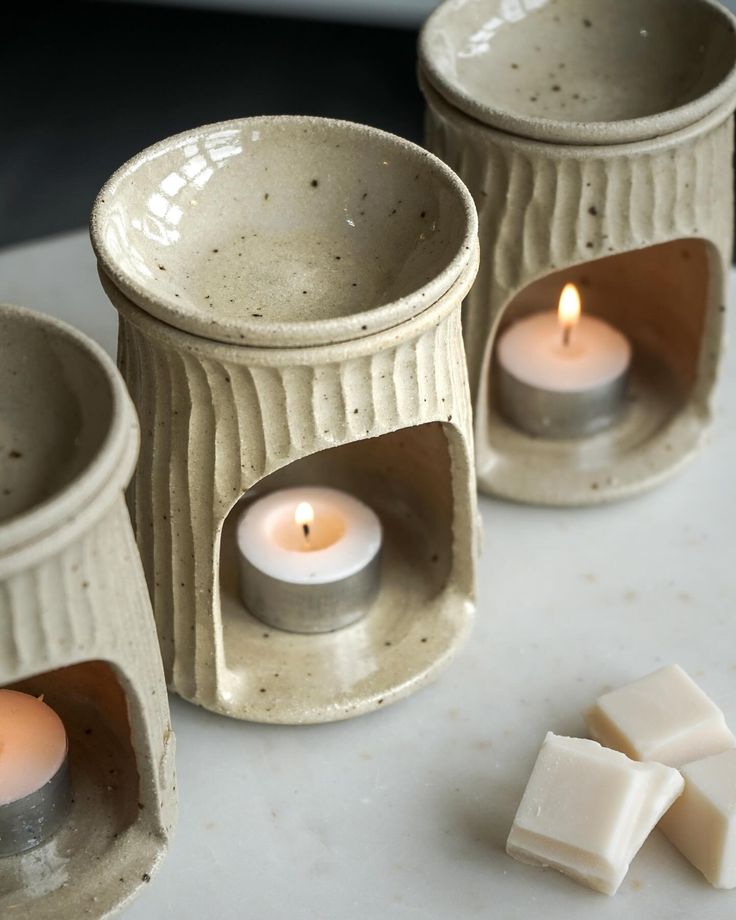 three candles are sitting on a table next to some pieces of wax