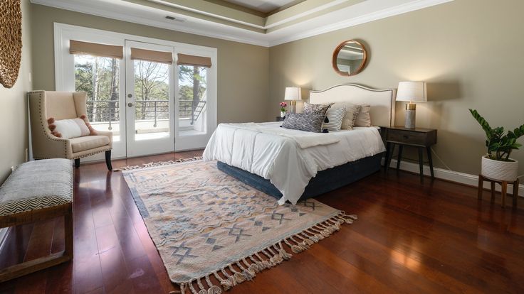 a large bed sitting in the middle of a bedroom on top of a hard wood floor