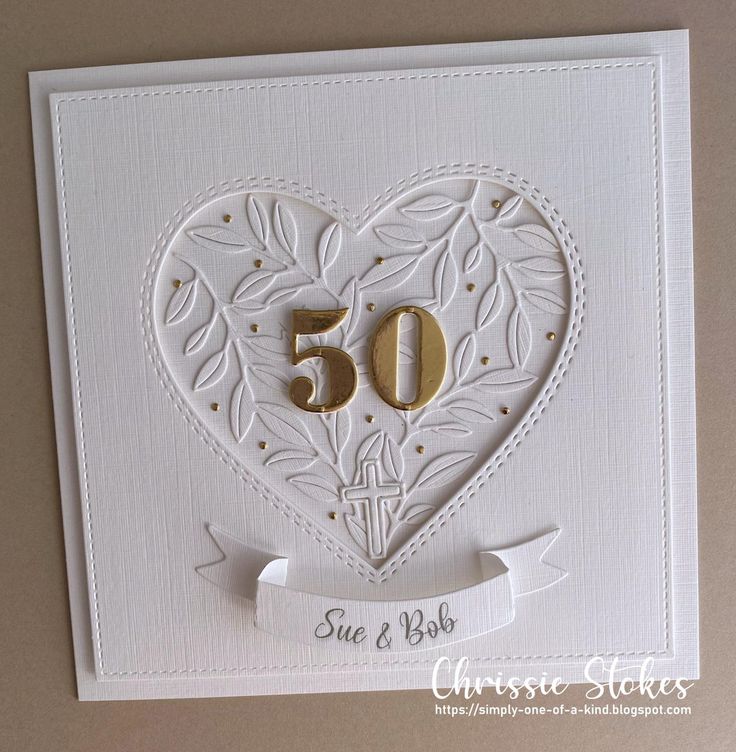 a card with the number 50 on it and a ribbon in the shape of a heart