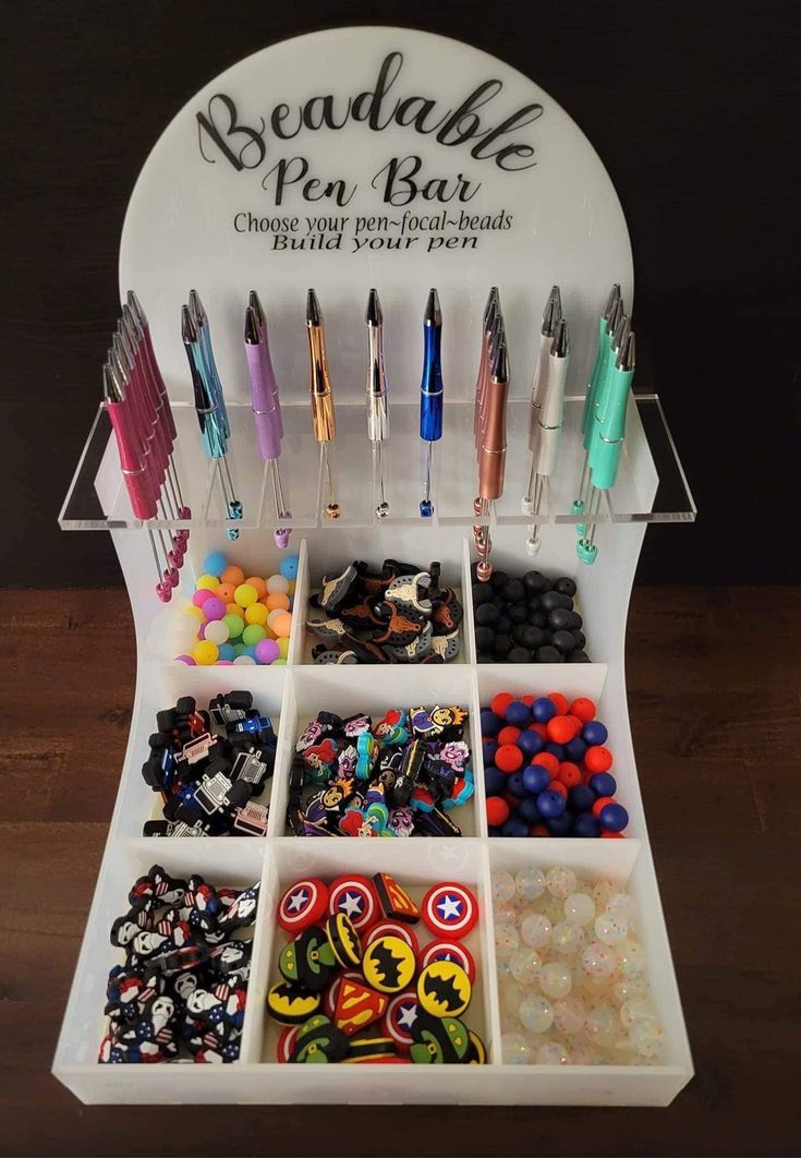 a display case filled with lots of different types of buttons and pens on top of a wooden table