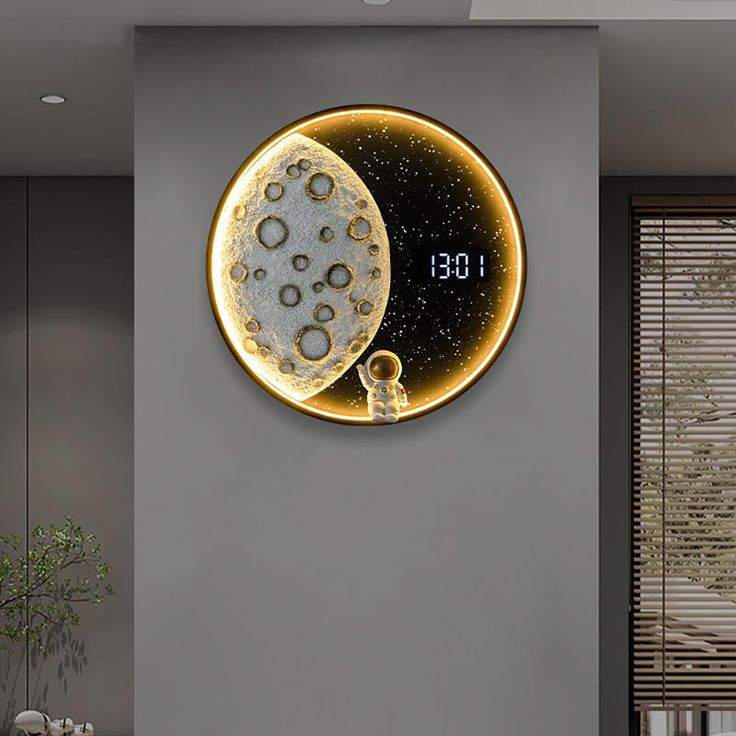 a clock that is on the wall next to a table with a vase and potted plant