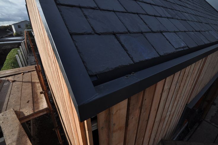 the roof of a building is being built with wooden boards and shingles on it