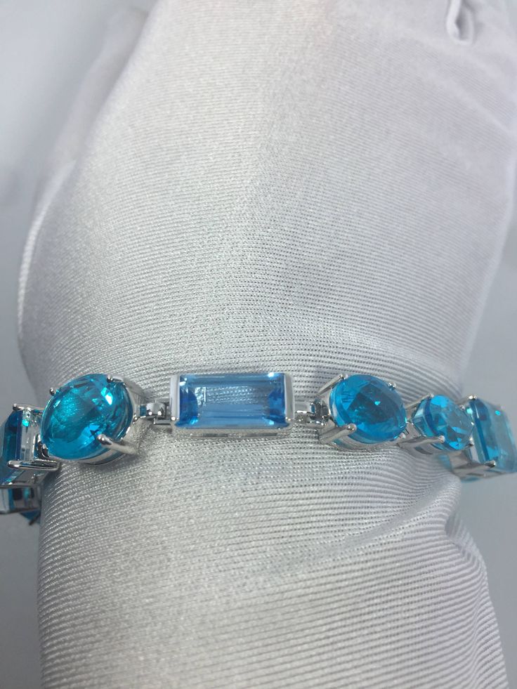 This Blue Topaz and Blue Quartz bracelet is very lively and bright. The stones are deep colors and different tones of blue The sterling silver is plated with rhodium to protect the bracelet from tarnish and give the appearance of white gold. 8 inches All jewelry is shipped in a nice gift box. Check out our over a THOUSAND great reviews Engraving is $4 per letter and is not always perfect depending on the piece. It can take a few days if the jeweler is busy. This is payable to Paypal Judithsltd@g Modern Blue Multi-stone Jewelry, Elegant Blue Aquamarine Bracelets, Elegant Blue Multi-stone Bracelet, Elegant Blue Multi-stone Bracelets, Blue Aquamarine Multi-stone Jewelry, Blue Multi-stone Aquamarine Jewelry, Modern Blue Gemstone Bracelet, Modern Blue Gemstone Bracelets, Modern Blue Aquamarine Jewelry