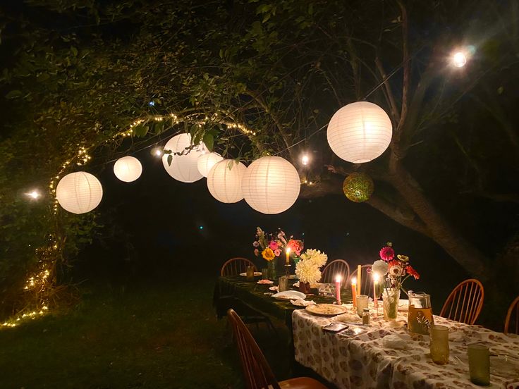 a long table with paper lanterns hanging from it