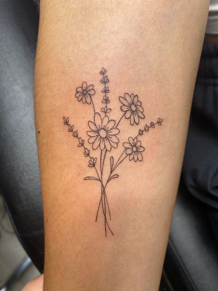 a woman's leg with a tattoo on it that has flowers in the middle