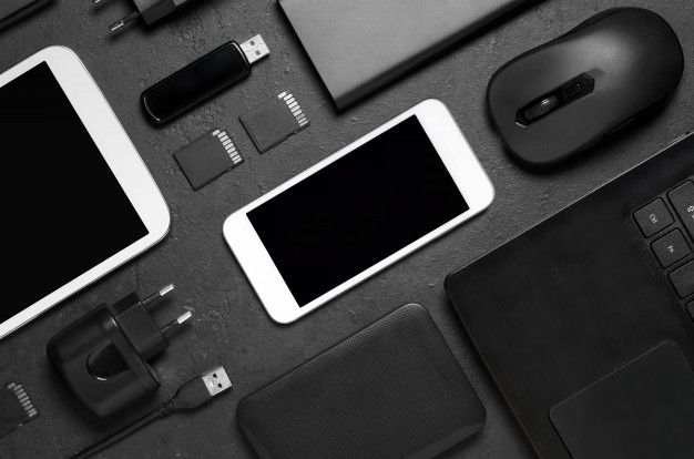 an assortment of electronic devices and accessories laid out on a table