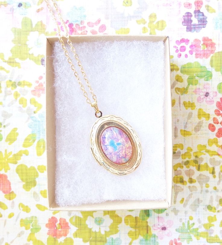 "A gorgeous gold plated photo locket adorned with a lovely pink fire opal dangles so pretty from a 16k gold plated link chain with lobster clasp. Total length of chain measures 18\" Locket measures 23x30mm Fire Opal measures 18x13mm Locket is high quality and nickel free Please note that this is not a real opal, but a faux opal glass cabochon with incredible fire and flecks of blue, yellow, green and pink Opal being the birthstone for October makes this a perfect birthday gift Your purchase will Opal Locket, Pink Fire, Gold Locket Necklace, Feather Hair Clips, October Birthday, Wedding Hair Clips, Gold Locket, Photo Locket, Pink Opal