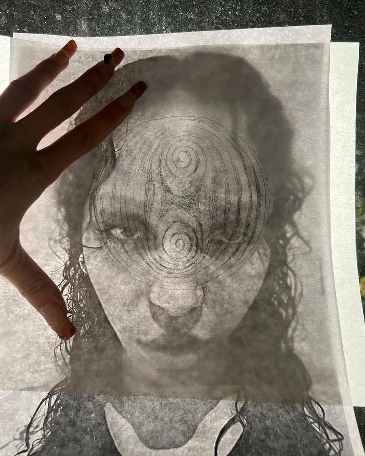 a person's hand is shown over a drawing of a woman with circles on her face