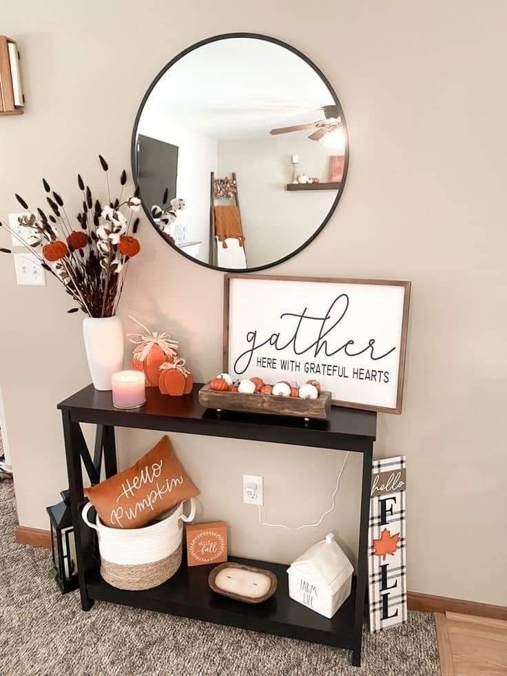 a black table topped with a mirror next to a vase filled with flowers and other items