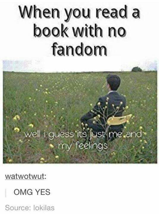 a man sitting in the middle of a field next to a book with no fandom written on it