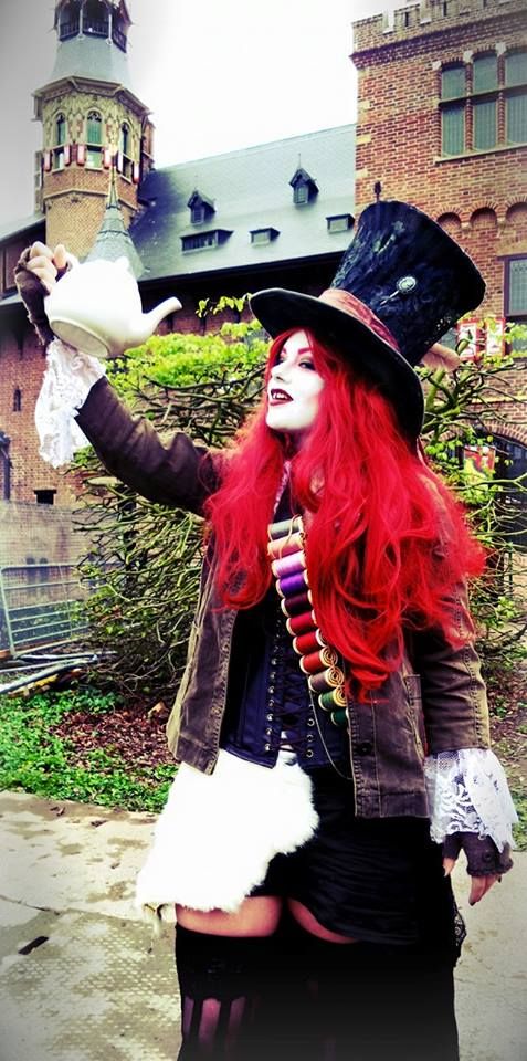 a woman with red hair wearing a top hat and costume