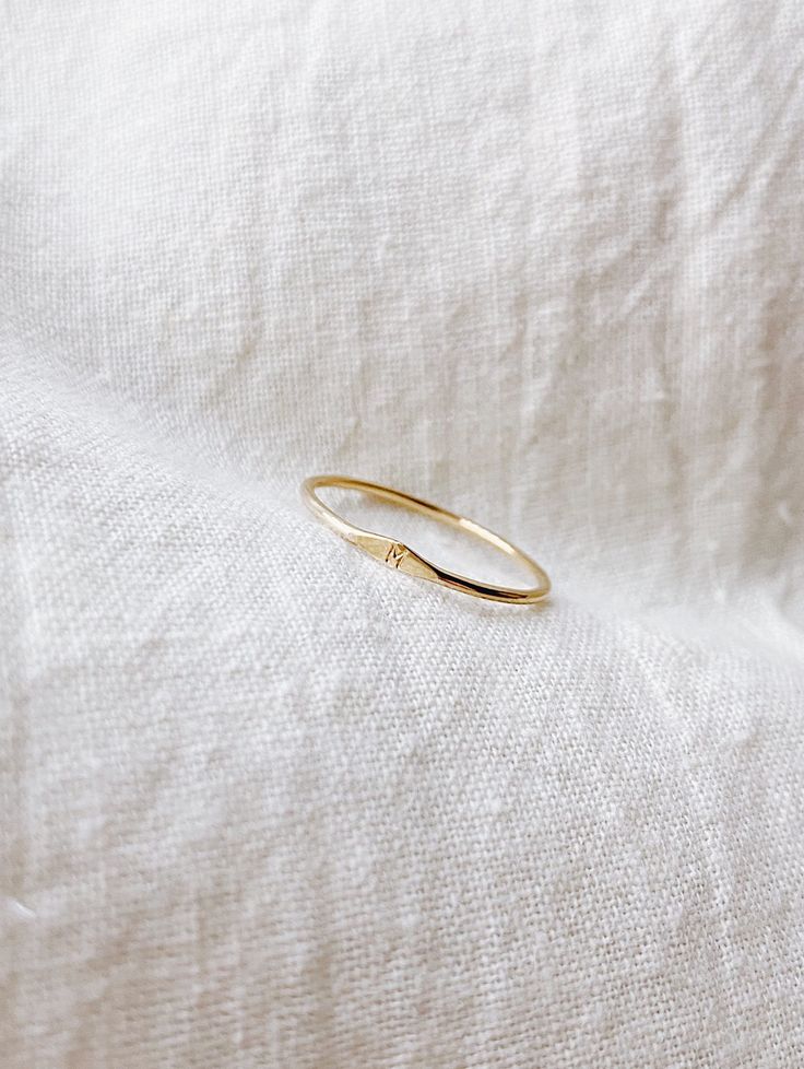 MICRO SIGNET RING A solid 14k gold ring that has a dimple on a ring with a tiny initial/letter of choice. Each ring is madd-to-order with love and is carefully handcrafted (may be slightly different than picture). This is a perfect everyday ring that is great for gifting. + 1mm band solid 14k Yellow Gold ring + Micro initial + Comes in a box + Available characters in Capital letters from dropdown bar: A B C D E F G H I J K L M N O P Q R S T U V W X Y Z + Please note all Mantle 14k gold pieces ar M Jewelry Letter, M And P Letter Love, M Ring Letter, Dainty 14k Gold Initial Ring Tarnish Resistant, Gold Minimalist Initial Ring With Round Band, Dainty 14k Gold Initial Ring With Round Band, 14k Yellow Gold Initial Ring For Everyday, Dainty 14k Gold Stackable Rings With Initials, Simple Stackable Initial Ring In Yellow Gold