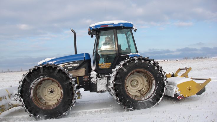 a tractor is plowing the snow with it's front wheels