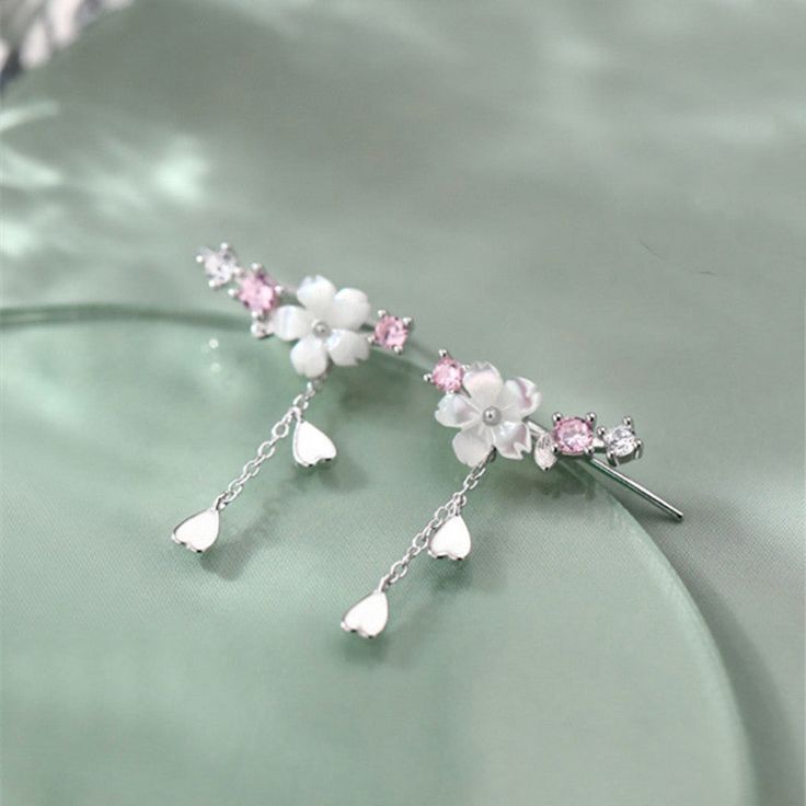 Description & Details Immerse yourself in the ethereal beauty and fleeting nature of cherry blossoms with our exquisite pieces inspired by these delicate blooms. Each design in our collection is meticulously crafted to capture the grace and elegance of cherry blossoms in full bloom. • Material: Solid 925 Sterling Silver ∙ Shell ∙ Cubic Zirconia • Finish: Hypoallergenic ∙ Gold Plating• Dimensions: 13 x 8 mm each• All our work is custom made by hand with love Cherry Blossom Earrings, Bra And Thong, In Full Bloom, Ethereal Beauty, The Grace, Cherry Blossoms, Cute Jewelry, Solid 925 Sterling Silver, Gold Plating