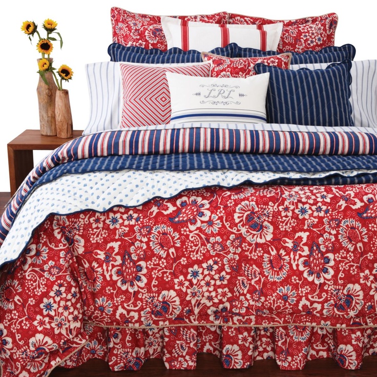 a bed with red, white and blue comforters on it