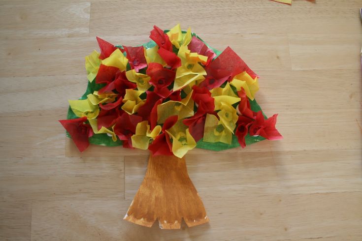 a wooden table topped with paper flowers and scissors