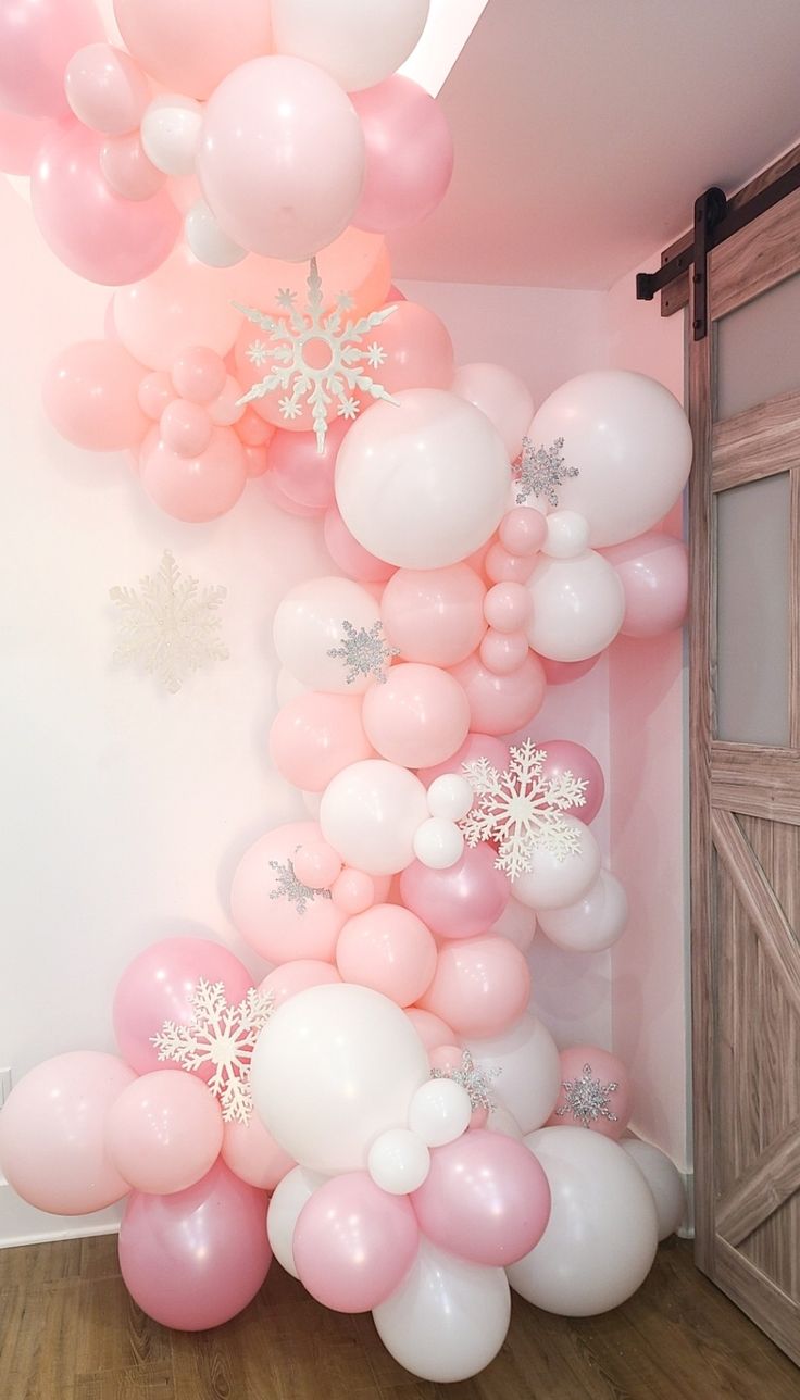 a room with balloons and snowflakes hanging from the ceiling